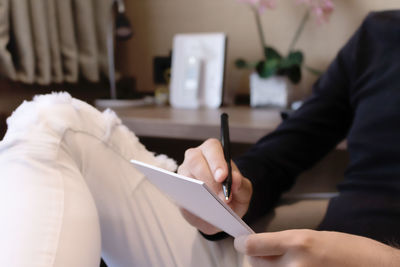 Midsection of man holding camera on table