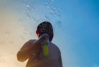 Full length of woman holding bubbles