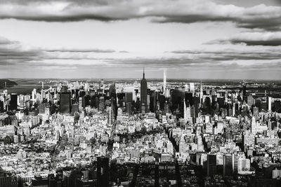 View of cityscape against cloudy sky