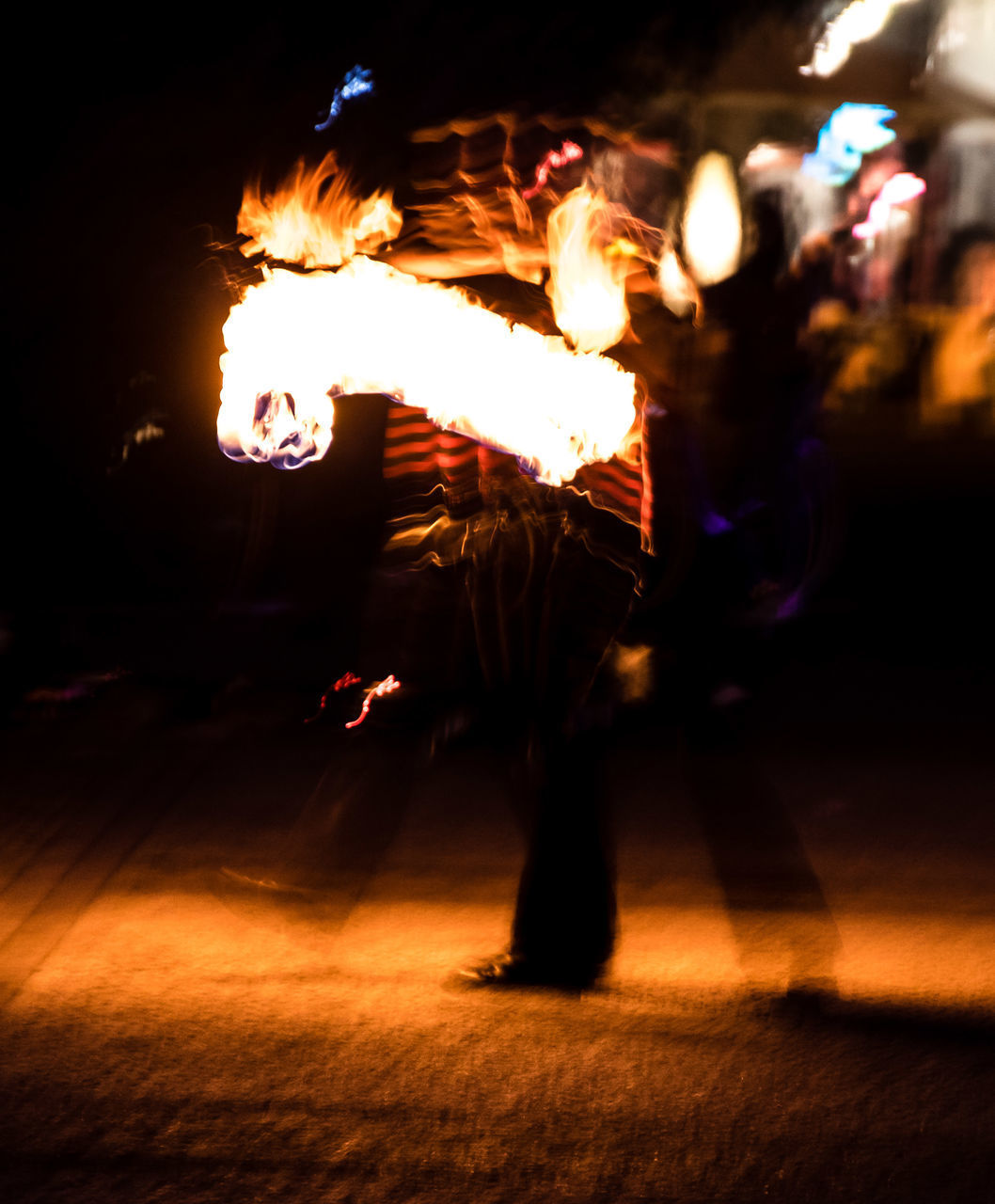 BLURRED MOTION OF MAN WITH FIRE CRACKERS AT NIGHT DURING FESTIVAL