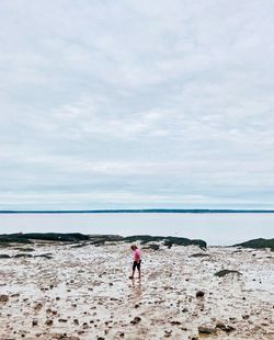 Full length of girl on beach against sky