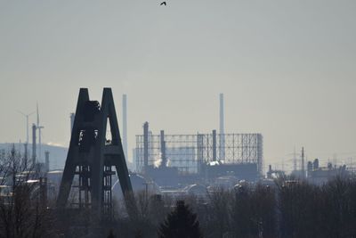 Construction site by buildings against clear sky