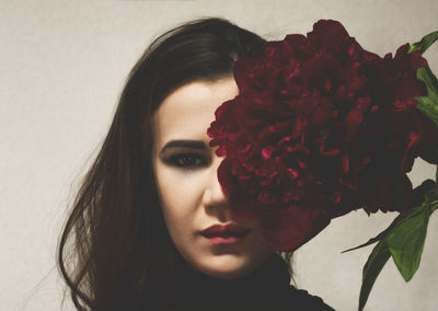 Close-up of young woman with red rose