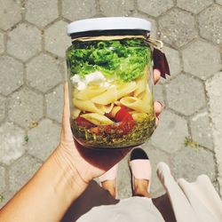 Cropped image of woman holding food in jar