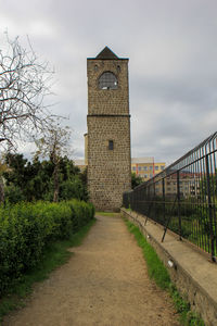 Footpath amidst buildings against sky