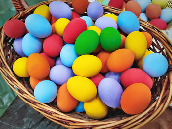 Pile of vibrant colorful fermented eggs in woven basket