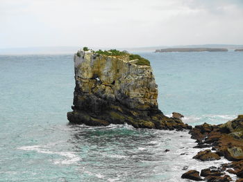 Rock formation in sea against sky