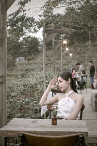 Side view of woman using mobile phone while sitting at park