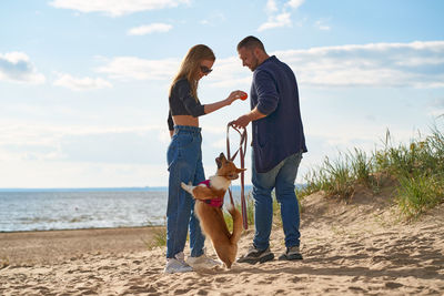 Smiling couple with dog at beach