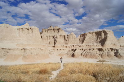 Man standing on rock formations against sky