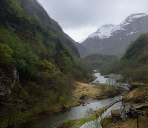 Scenic view of river and mountains against sky