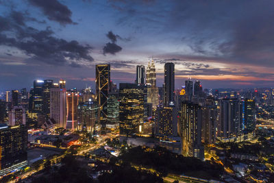 Illuminated buildings in city against sky