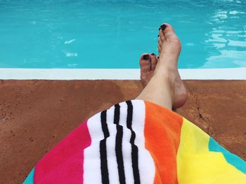 Low section of woman relaxing in swimming pool