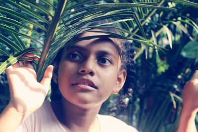 Portrait of young woman holding plant