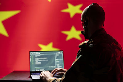 Rear view of man working at office