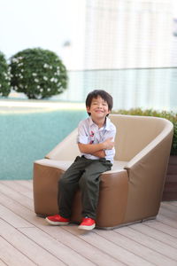 Portrait of smiling boy with brown sofa