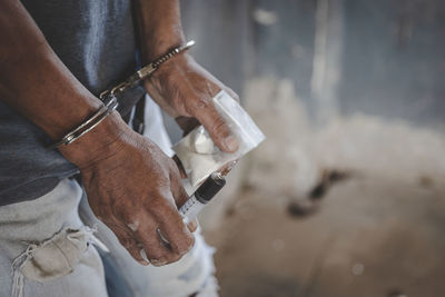 Cropped hand of man holding animal