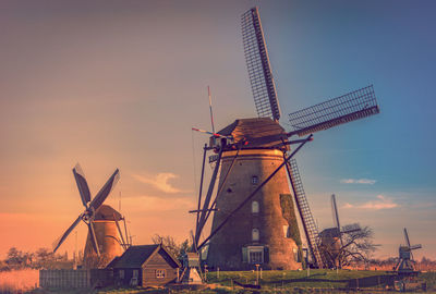 Traditional windmill on landscape against sky