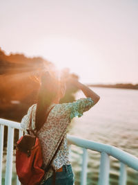 Rear view of woman standing at beach