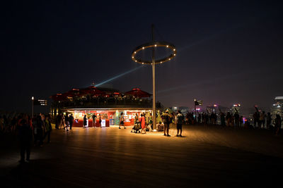 People on illuminated street lights in city at night