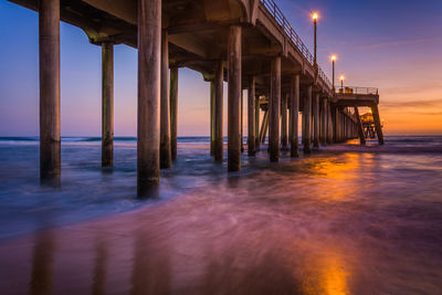 Pier on sea against sky during sunset