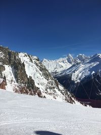 Scenic view of snowcapped mountains against clear blue sky