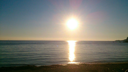 Scenic view of sea against clear sky at sunset