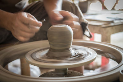 Midsection of man making clay pot