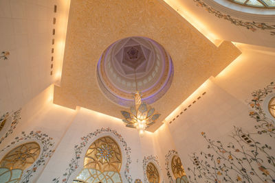 Low angle view of illuminated chandelier hanging in building