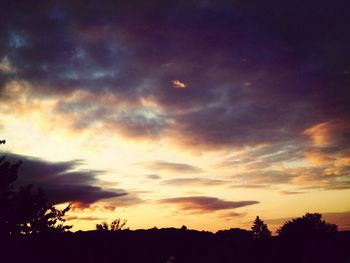 Silhouette of trees against cloudy sky