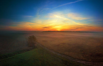 Scenic view of land against sky during sunset