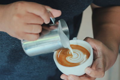 Midsection of man holding coffee cup