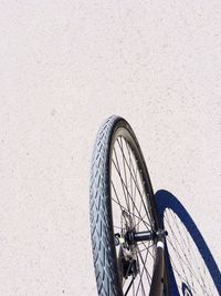 Cropped image of bicycle on street during sunny day