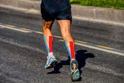 Low section of man running on road