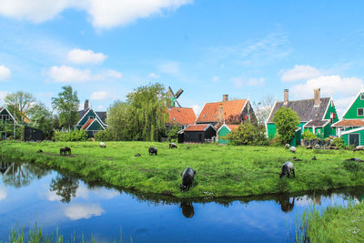 Scenic view of lake and houses against sky