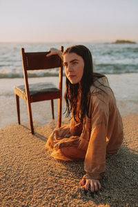 Portrait of young woman sitting on beach