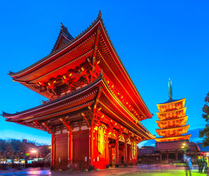Low angle view of illuminated temple against clear blue sky