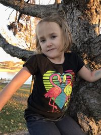 Portrait of cute girl with tree trunk