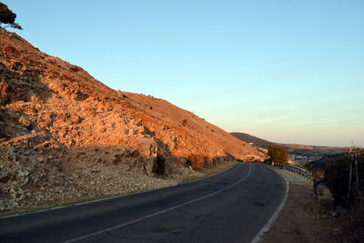 Road by mountain against clear sky