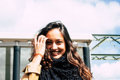 Portrait of smiling woman standing against sky