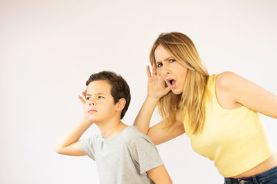 Low angle view of boy standing against white background