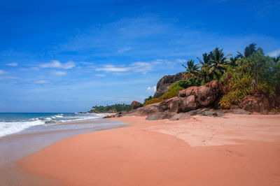 Scenic view of beach against blue sky