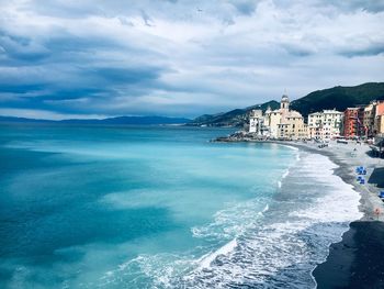 Scenic view of sea by buildings against sky