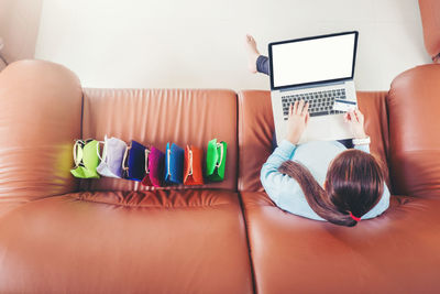 Midsection of woman using laptop on table at home