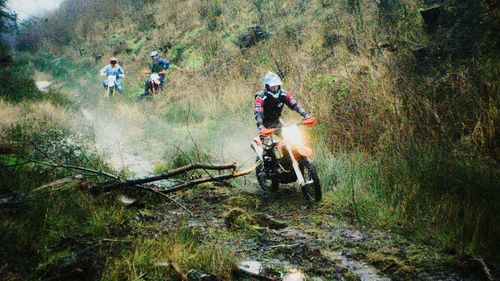 Motocross racer on move through forest