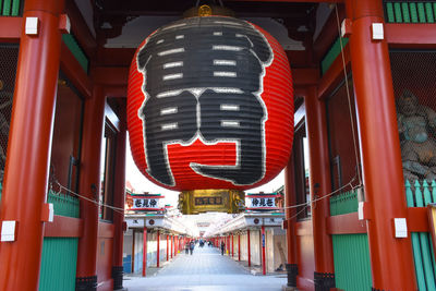 Road sign on footpath amidst buildings