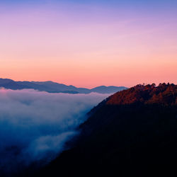 Scenic view of silhouette mountains against romantic sky at sunset