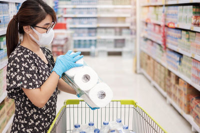 Woman holding toilet paper at shopping mall