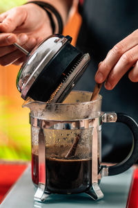 Midsection of woman making coffee in cafe