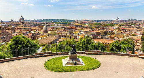 Statue in city against sky